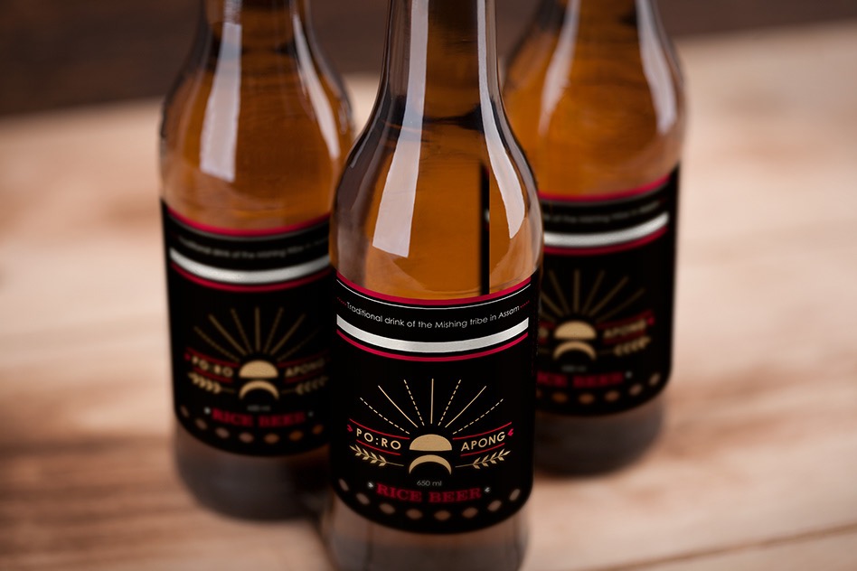 Three amber Po:ro Apong bottles on wood, black labels with gold mark and red Rice Beer type